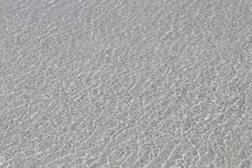Film of transparent Caribbean water over white sand