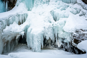Frozen arctic waterfall. Blue ice formation with white snow.