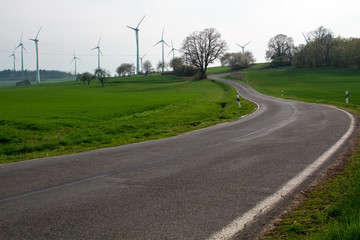 Road winding uphill to a wind farm