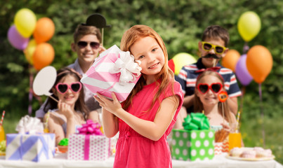 birthday and people concept - lovely red haired girl with gift box over party at summer park