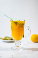 Freshly squeezed orange juice with pulp, kiwi and lemon on a light background. Vertical orientation