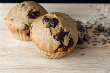 Homemade muffins with oats and seeds on wooden table