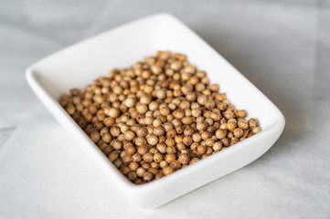 Coriander seeds on a white plate