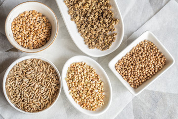 Grains of wheat, rye, buckwheat, beet and coriander on a white plates