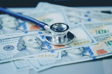 Financial analysis, audit or accounting - Stethoscope over a calculator and dollar bills. Medical costs, financial concept