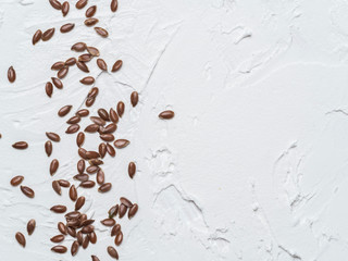 Flax seeds with copy space. Brown flax seed on white concrete textured background. Top view or flat lay. Copy space. Healthy food and diet concept