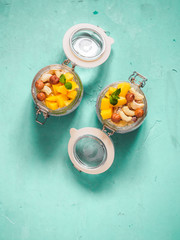 Chia seed pudding in jar with coconut milk, mango and nuts