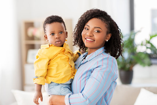 childhood, kids and people concept - happy african american mother with her baby son at home
