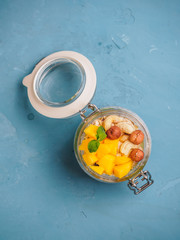 Chia seed pudding in jar with coconut milk, mango and nuts