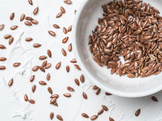 Flax seeds with copy space. Brown flax seed on white concrete textured background. Top view or flat lay. Copy space. Healthy food and diet concept