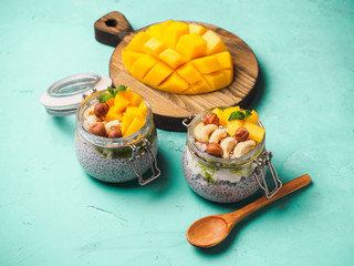 Chia seed pudding in jar with coconut milk, mango and nuts