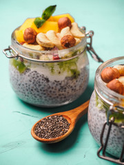 Chia seed pudding in jar with coconut milk, mango and nuts