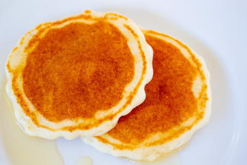 Image of pancakes dripped with wild honey on a dish close up.