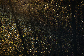 Fototapeta premium Beautiful rain drops on car glass while heavy traffic jam at night. Beautiful rain drop on glass background with colorful lighting from a cars and street.