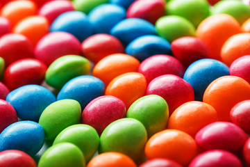 Rainbow colors of multicolored candies close-up, texture and repetition of dragee