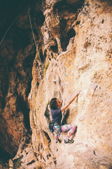 A girl climbs a rock.