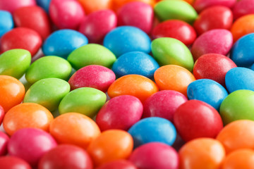 Rainbow colors of multicolored candies close-up, texture and repetition of dragee