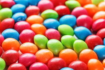 Rainbow colors of multicolored candies close-up, texture and repetition of dragee