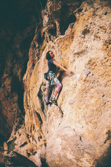 A girl climbs a rock.