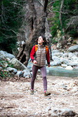 Naklejka na ściany i meble A girl with a backpack is on a mountain path.