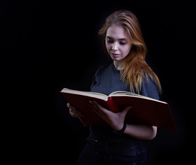 young girl reading a book on a black background