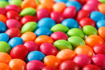 Rainbow colors of multicolored candies close-up, texture and repetition of dragee