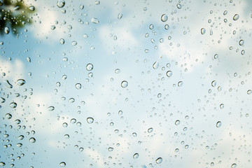 Rain drops on a glass of car in background.