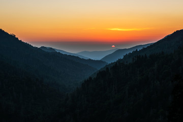 Obraz premium Sunset at Morton's Overlook below Newfound Gap on the border of Tennessee and North Carolina. The mist of the ancient Smoky Mountains glows in the setting sun.