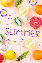 Colorful summer concept flat lay with fresh juice, tropical fruits, lollipops and multicolor seashells, copyspace