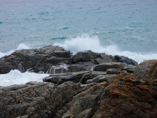 Fototapeta premium Olas estrellándose contra las rocas y generando espuma