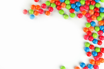 A rainbow of color from multicolored candies close-up, multi-colored glaze dragee on a white background