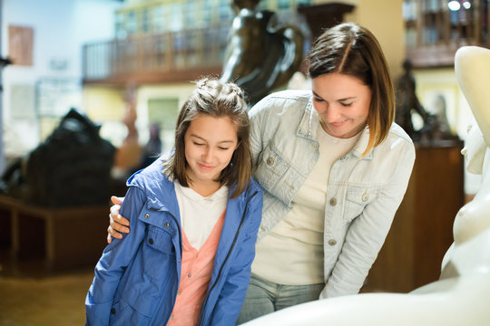 Mother and daughter exploring antique statues