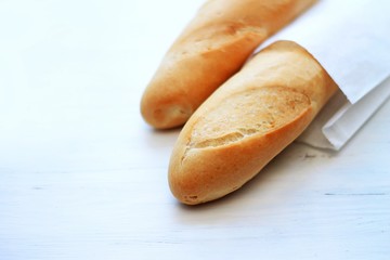 french baguettes, loaves on a light wooden background