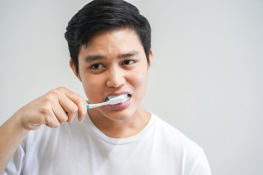 close up young asian man brushing teeth at bathroom in the morning , lifestyle daily concept	