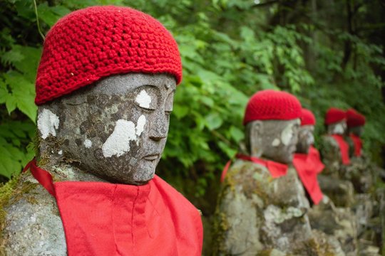 Statues of Ksitigarbha bodhisattva (Jizo) with red caps and bibs in Nikko, Japan