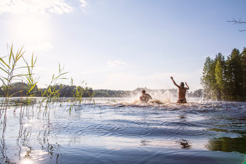 A man and a woman bathe and have fun in a clean, forest lake, on a hot, summer day. Active tourist...