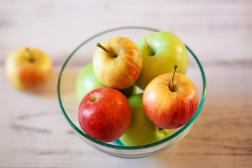 Fresh organic apples on a wooden table in a plate. Natural light. Selective focus