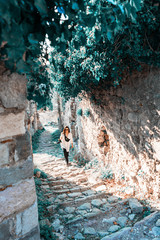 Young woman going for a walk on ancient ruins in Europe. Traveler and blogger.