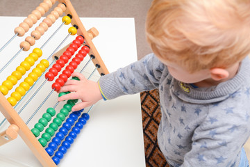 Child learning to count. Young boy using an abacus to learn maths
