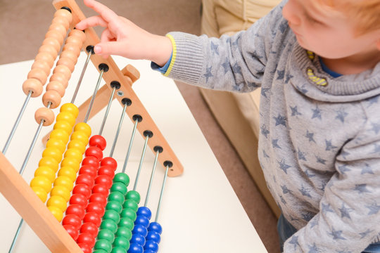 Child learning to count. Young boy using an abacus to learn maths