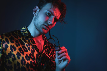 Fashion art neon light studio portrait of stylish man model with leopard shirt and glasses. Glamour light. © Yevhen