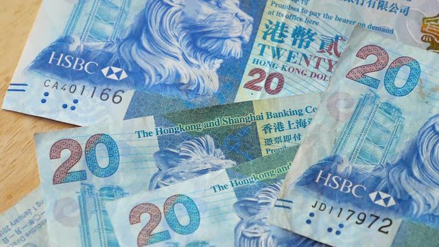 Slow motion 20 Hong Kong Dollars banknote, HKD money falling on wood table