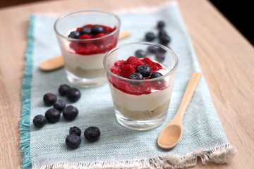 Simple no-bake raspberry cheesecake in a glass. Decorated with blueberries. Selective focus.