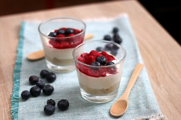 Simple no-bake raspberry cheesecake in a glass. Decorated with blueberries. Selective focus.