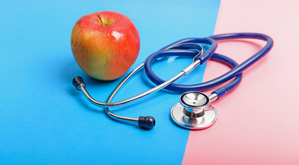 Stethoscope and apple between blue and red areas