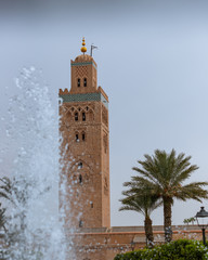 Koutoubia mosque in Marrakesh, Morocco, surrounded by palm trees and a water fountain