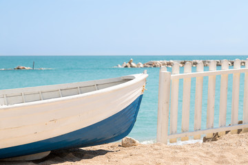 Obraz premium Summer photo of boat on sand and sea landscape. Wooden fishing boat on the beach with blue sky - Imagine