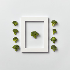 Organic vegetables pattern with broccoli in a frame and out of it on a light background.