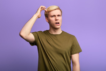 puzzled man scratching head with finger, thinking about something, guy isn't sure in his answer. Human facial expression, emotion, sign body language.