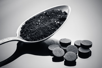 Close up activated carbon in a spoon